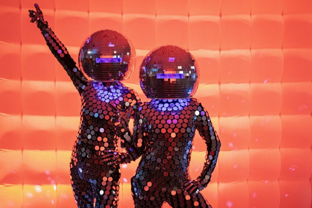 Two performers posing in front of a inflatable wall at EXPERIENCEit 2024